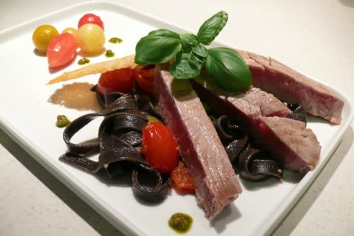 Kort gebakken tonijn, zwarte (sepia)tagliatelle, gemarineerde tomaten, pesto
